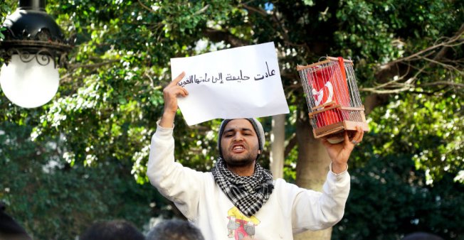Sarah Leduc _Sulla viale Bourguiba di Tunisi, un uomo ha messo una bandiera in gabbia domenica_14 gennaio_come simbolo della Tunisia ai tempi di Ben Ali