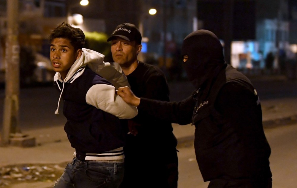 Un giovane tratto in arresto a Ettadhamen, sobborgo di Tunisi © LaPresse