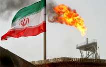 FILE PHOTO: A gas flare on an oil production platform in the Soroush oil fields is seen alongside an Iranian flag in the Persian Gulf