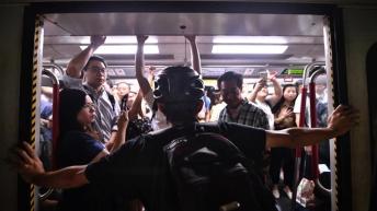 A protester blocks an underground commuter train from closing in Hong Kong on Monday _Anthony Wallace_AFP