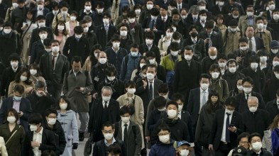 Commuters wear masks on their way to work in Tokyo, Japan_Kimimasa Mayama_EPA