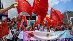 Pro-China supporters display Chinese and Hong Kong flags as they raise a toast with champagne during a rally near the government headquarters in Hong Kong on June 30_2020 Anthony Wallace_AFP